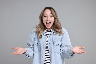 Photo of Portrait of happy surprised woman on grey background