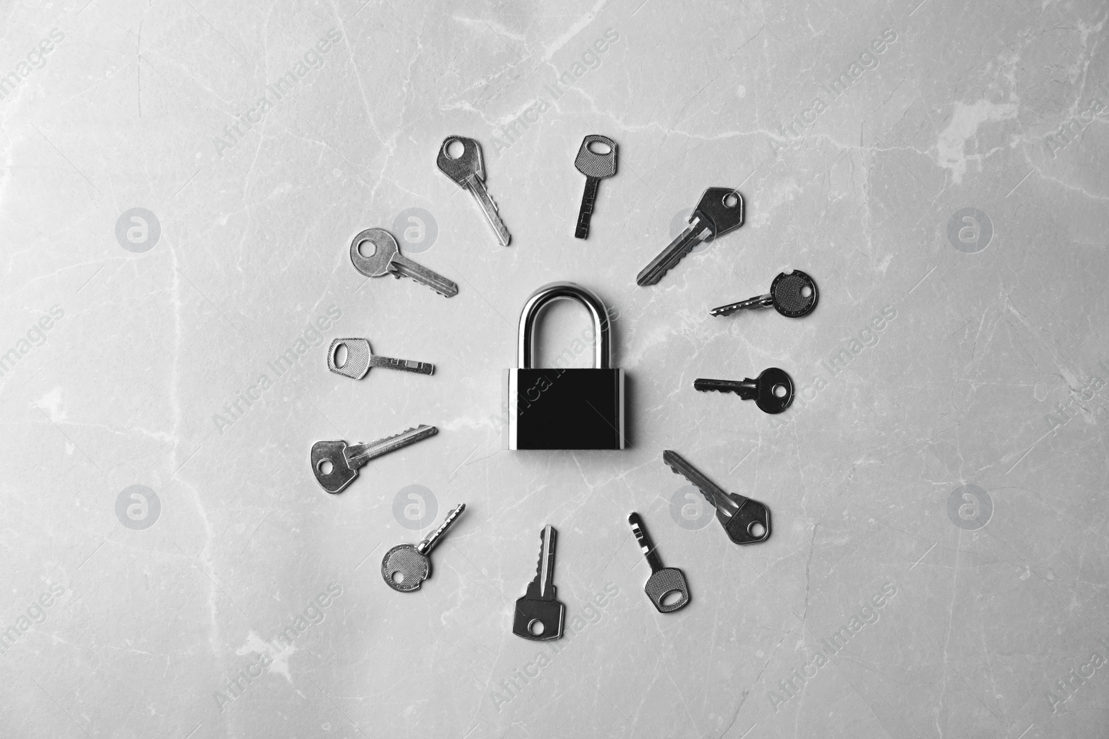 Photo of Steel padlock and keys on marble background, flat lay. Safety concept