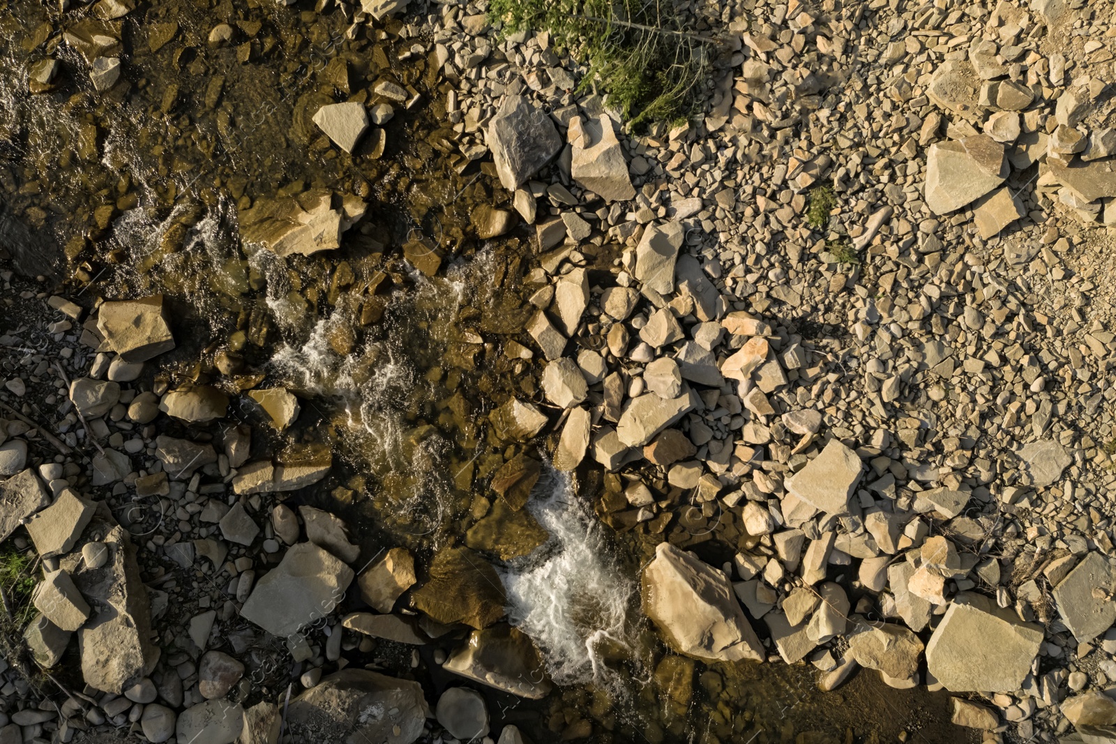 Image of Aerial view of rocky terrain with creek. Drone photography