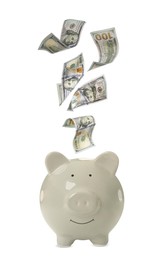 Image of Dollar banknotes falling into piggy bank on white background