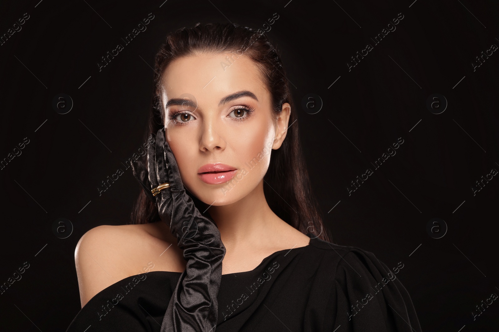 Photo of Portrait of beautiful young woman in elegant evening gloves on black background