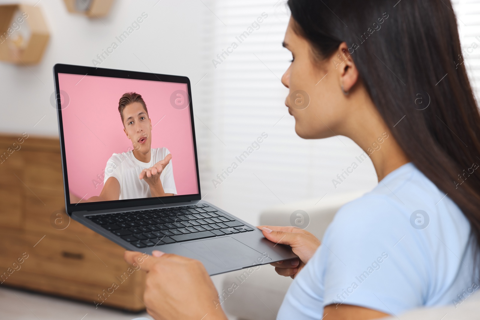 Image of Long distance love. Woman having video chat with her boyfriend via laptop at home