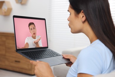 Long distance love. Woman having video chat with her boyfriend via laptop at home