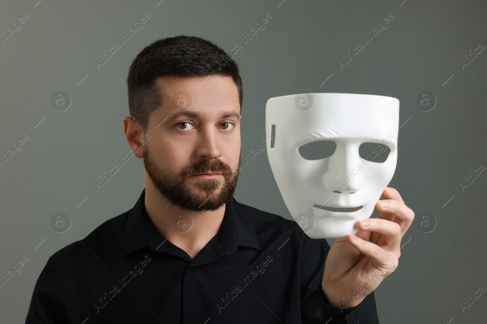 Photo of Multiple personality concept. Man with mask on grey background