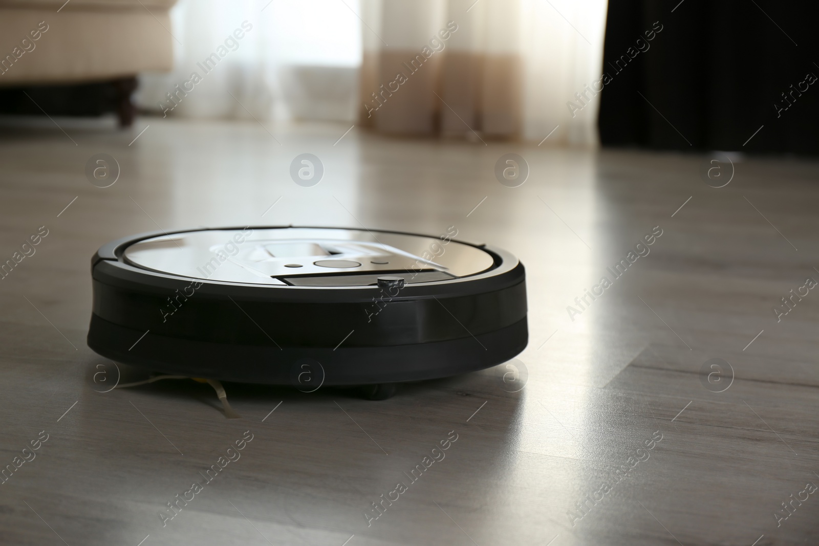 Photo of Modern robotic vacuum cleaner on wooden floor indoors