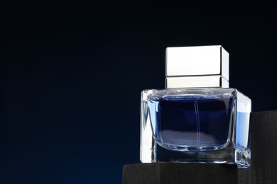 Photo of Luxury men`s perfume in bottle against dark background, space for text