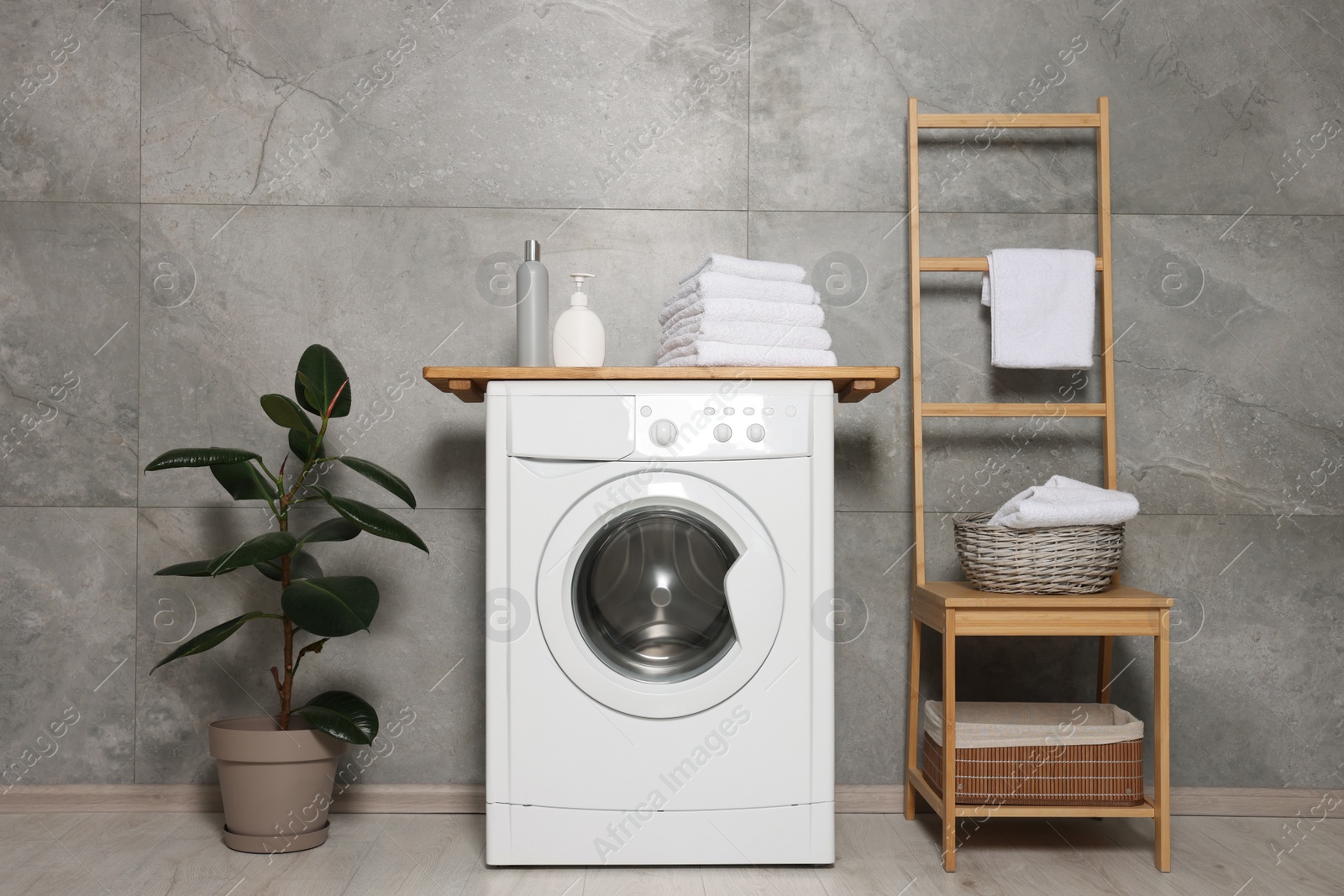 Photo of Stylish laundry room with modern washing machine. Interior design