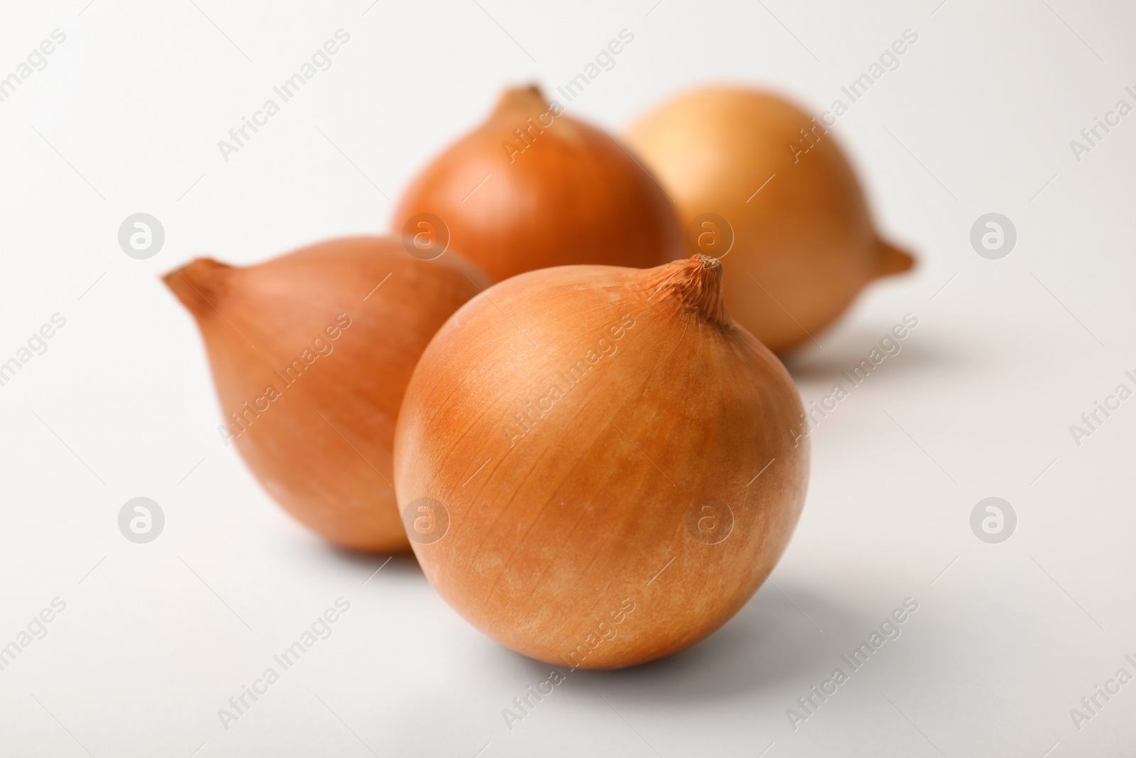 Photo of Fresh ripe onion bulbs on light background