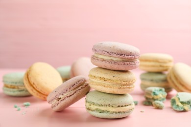 Photo of Delicious macarons on pink wooden table. Sweet dessert