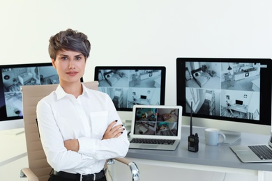 Photo of Female security guard at workplace with modern computers indoors