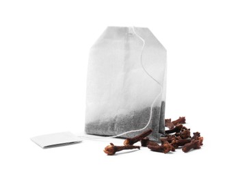 Tea bag and cloves on white background