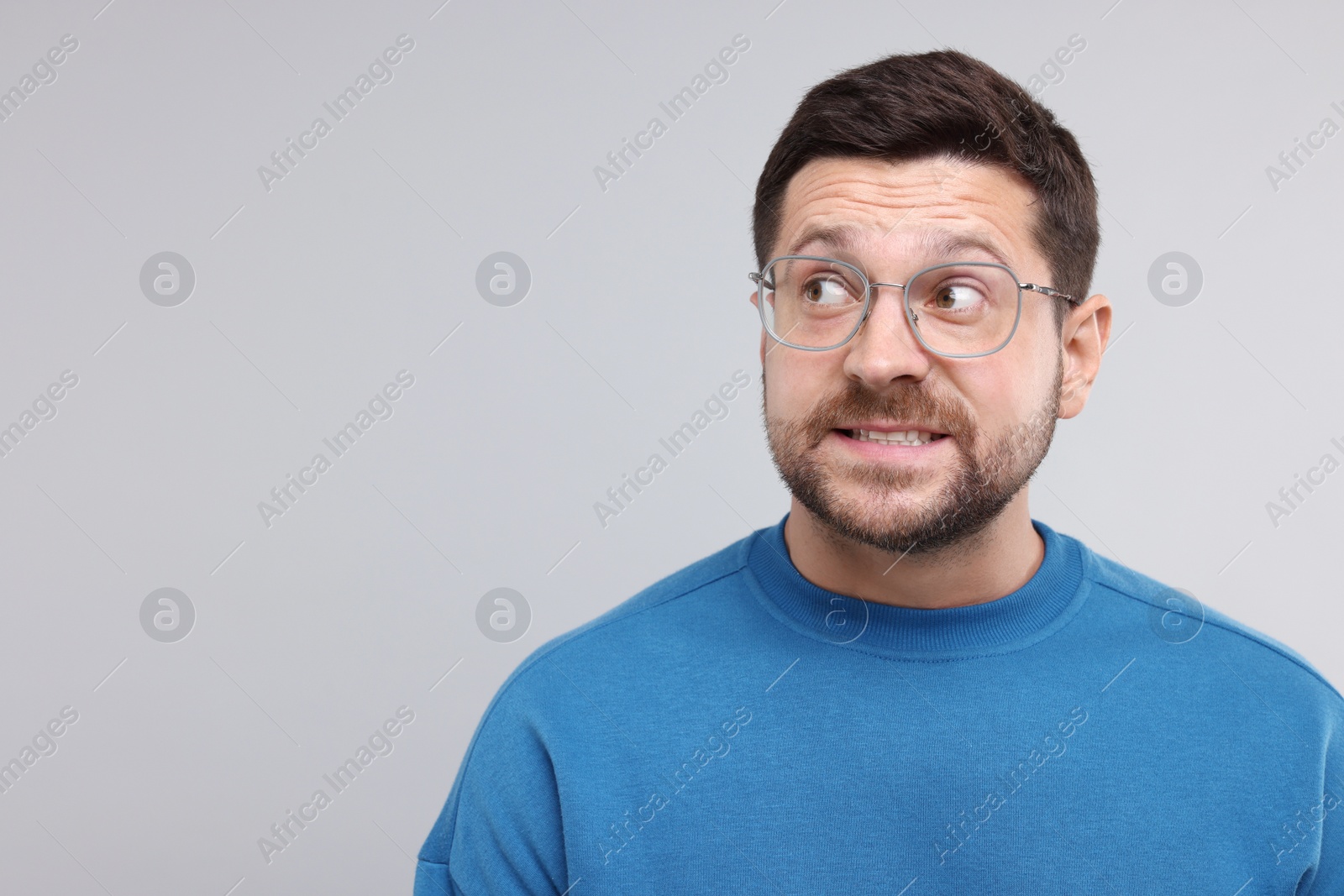 Photo of Embarrassed man on light grey background. Space for text