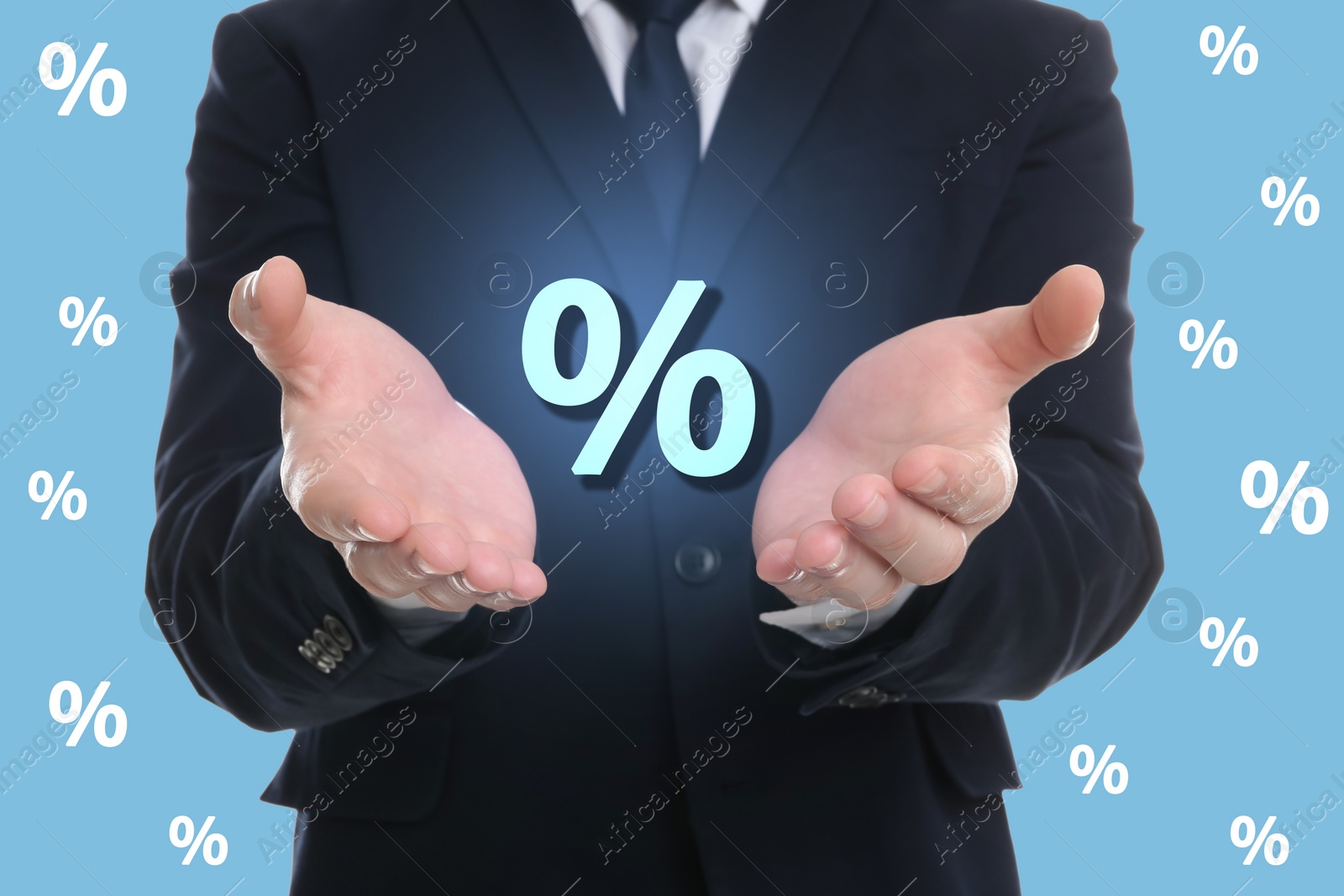 Image of Man showing virtual percent sign on light blue background, closeup. Discount concept