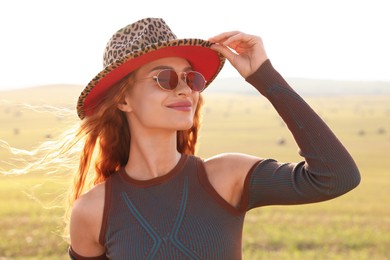 Beautiful happy hippie woman in hat in field