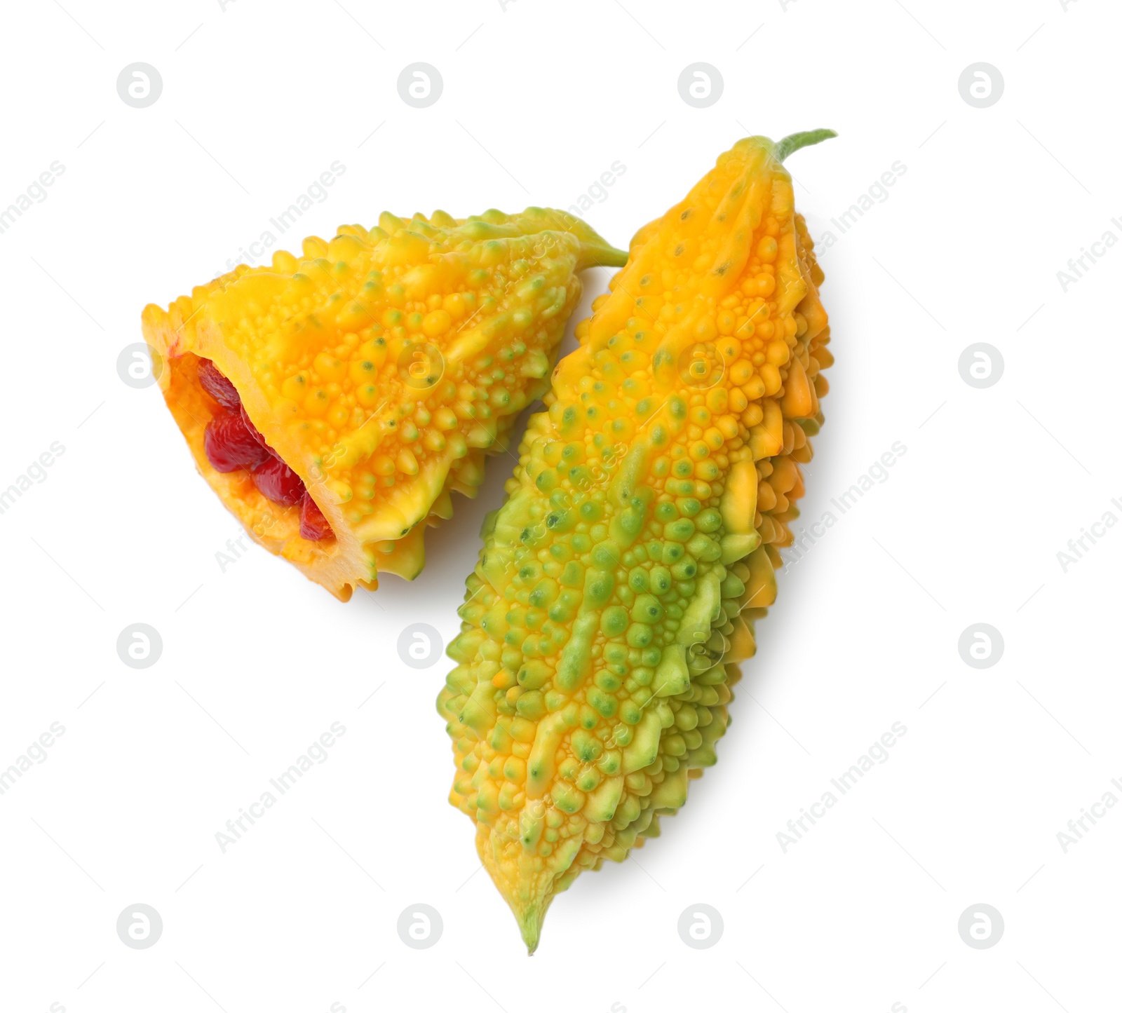 Photo of Whole and cut fresh ripe bitter melons on white background, top view