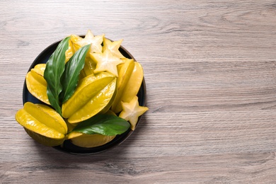 Delicious carambola fruits on wooden table, top view. Space for text