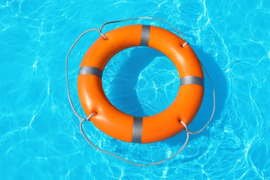 Lifebuoy floating in swimming pool on sunny day, top view