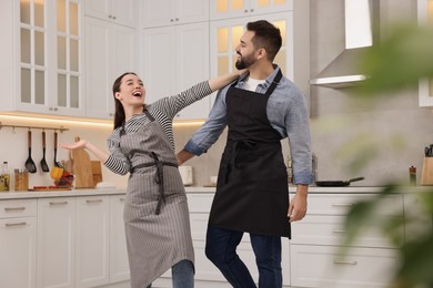 Photo of Happy lovely couple dancing together in kitchen