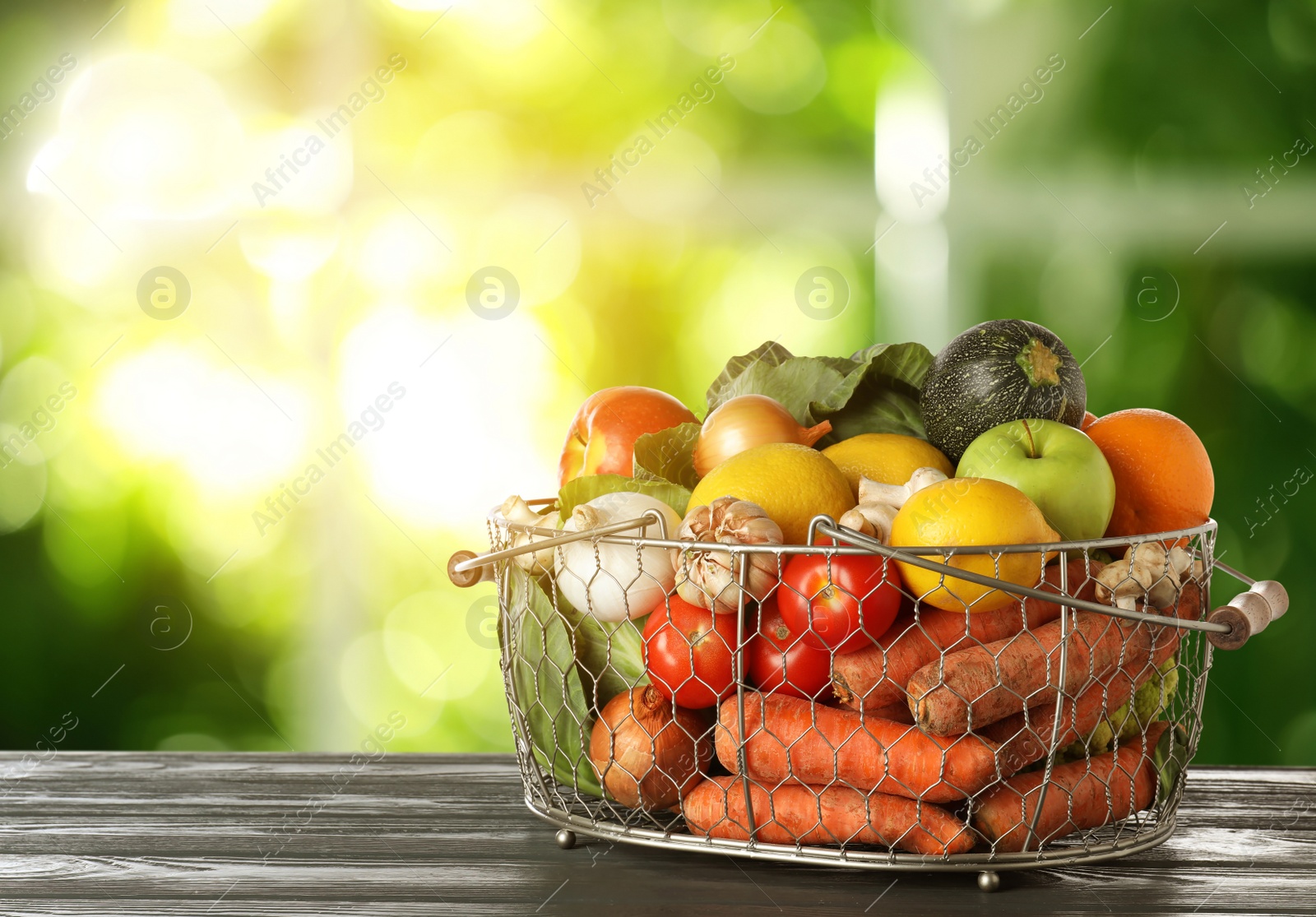 Image of Variety of fresh delicious vegetables and fruits in basket on table against blurred background, space for text
