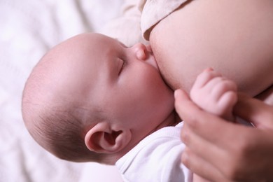 Photo of Mother breastfeeding her newborn baby, closeup view