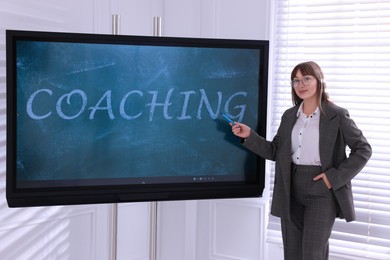 Photo of Business trainer using interactive board in meeting room