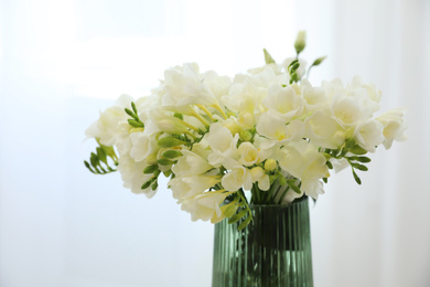 Photo of Beautiful bouquet with white freesia flowers in vase indoors