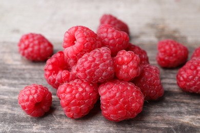 Photo of Tasty ripe raspberries on wooden table, closeup