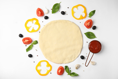 Flat lay composition with dough and fresh ingredients for pizza on white background