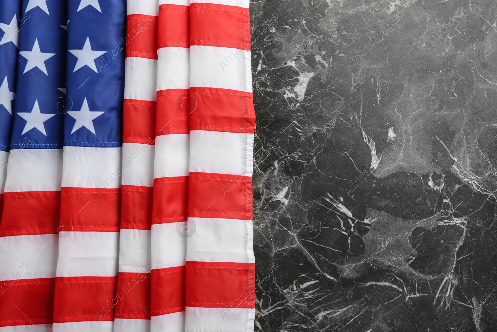 Photo of American flag on marble background, top view. Space for text