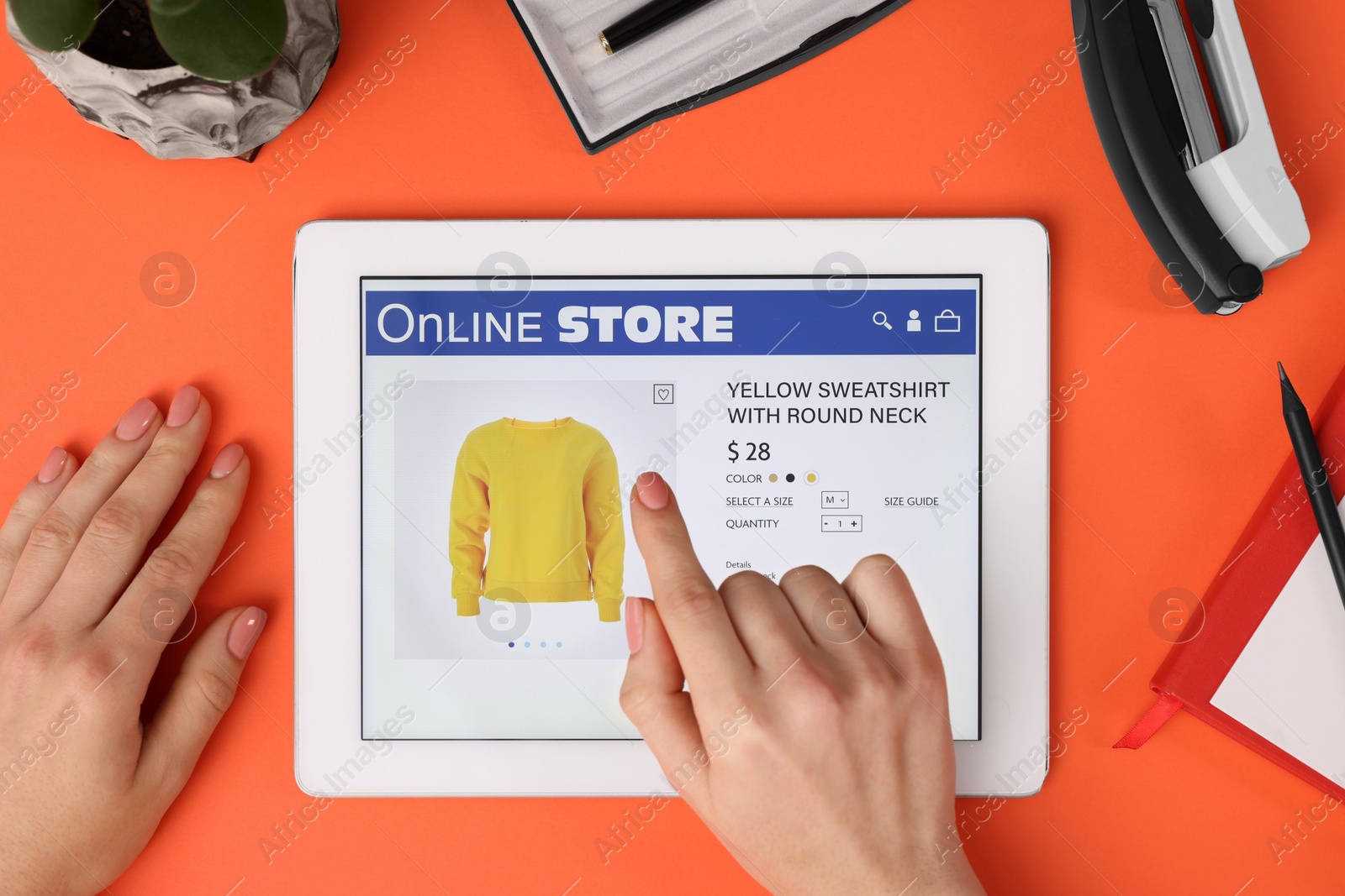 Photo of Woman with tablet shopping online on orange background, top view