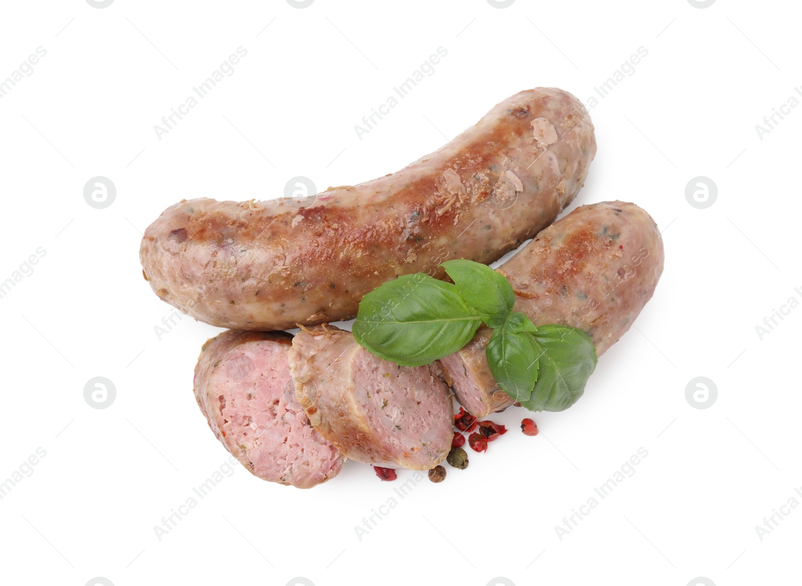 Photo of Tasty whole and cut homemade sausages, peppercorns and basil leaves isolated on white, top view