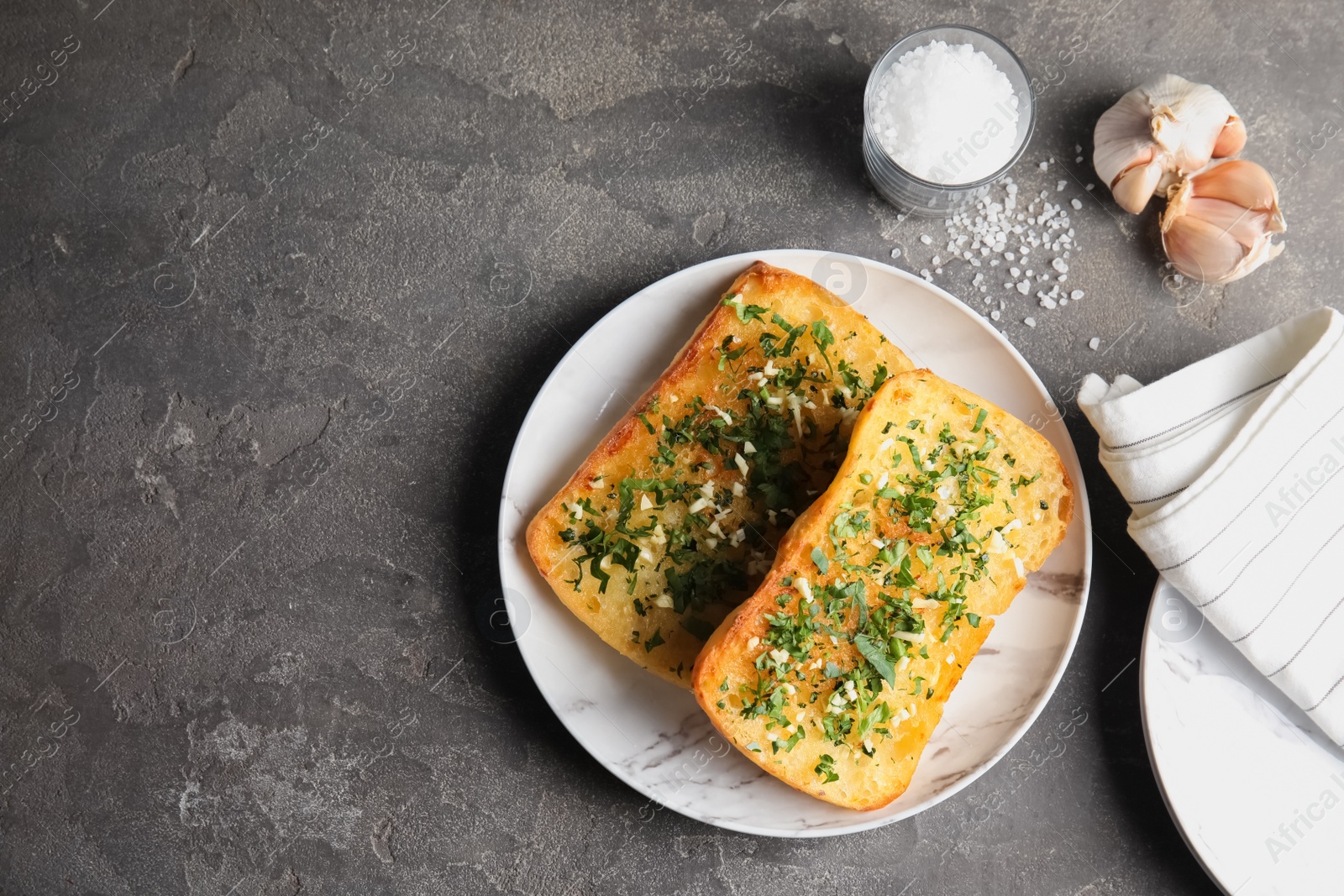 Photo of Flat lay composition with tasty homemade garlic bread and space for text on table