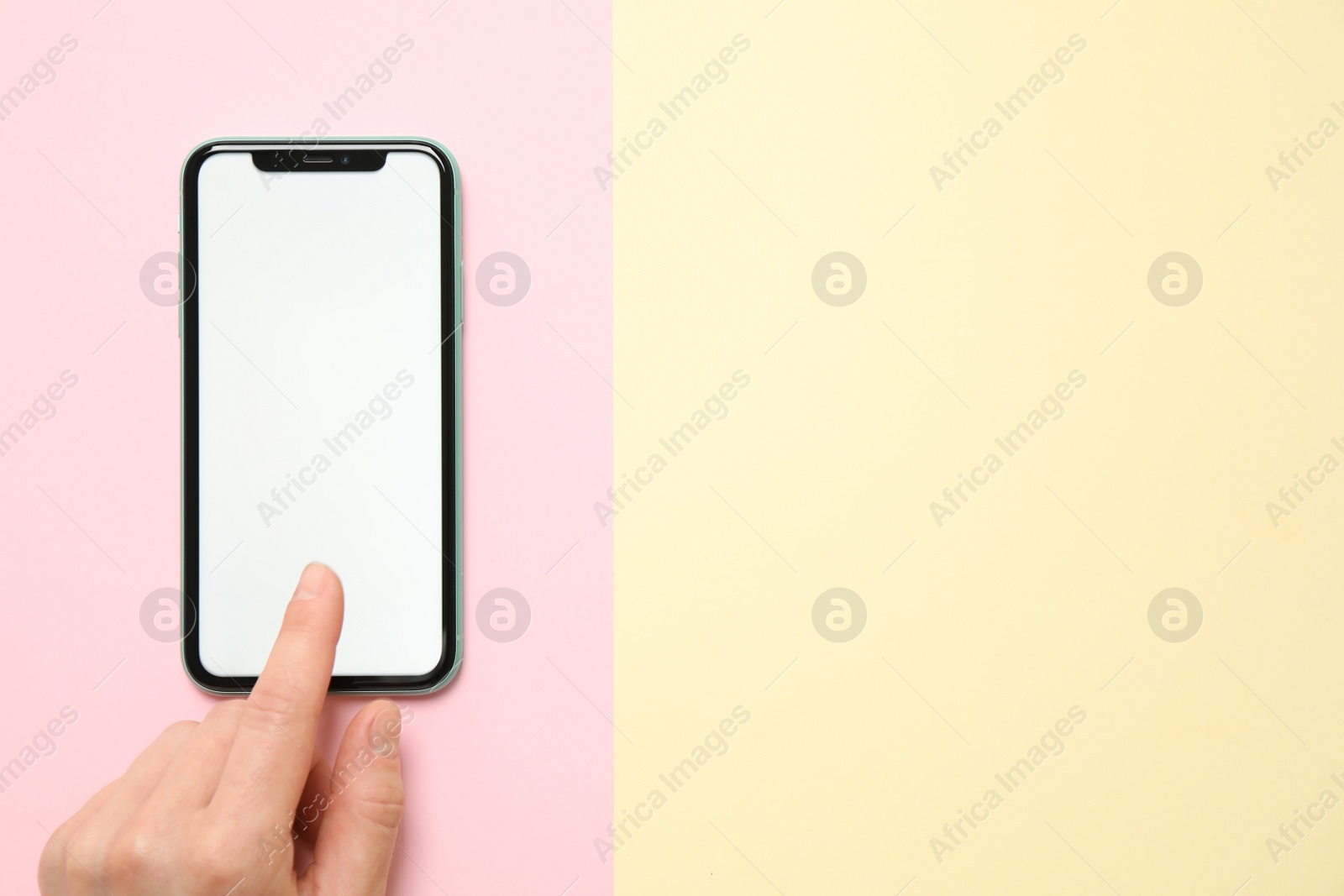 Photo of MYKOLAIV, UKRAINE - JULY 07, 2020: Woman using iPhone 11 on color background, top view. Mockup for design