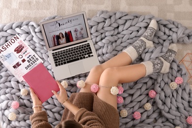 Woman and laptop with beauty blogger site on floor, top view