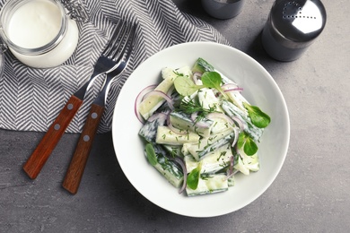 Photo of Plate with creamy cucumber salad served on table, top view