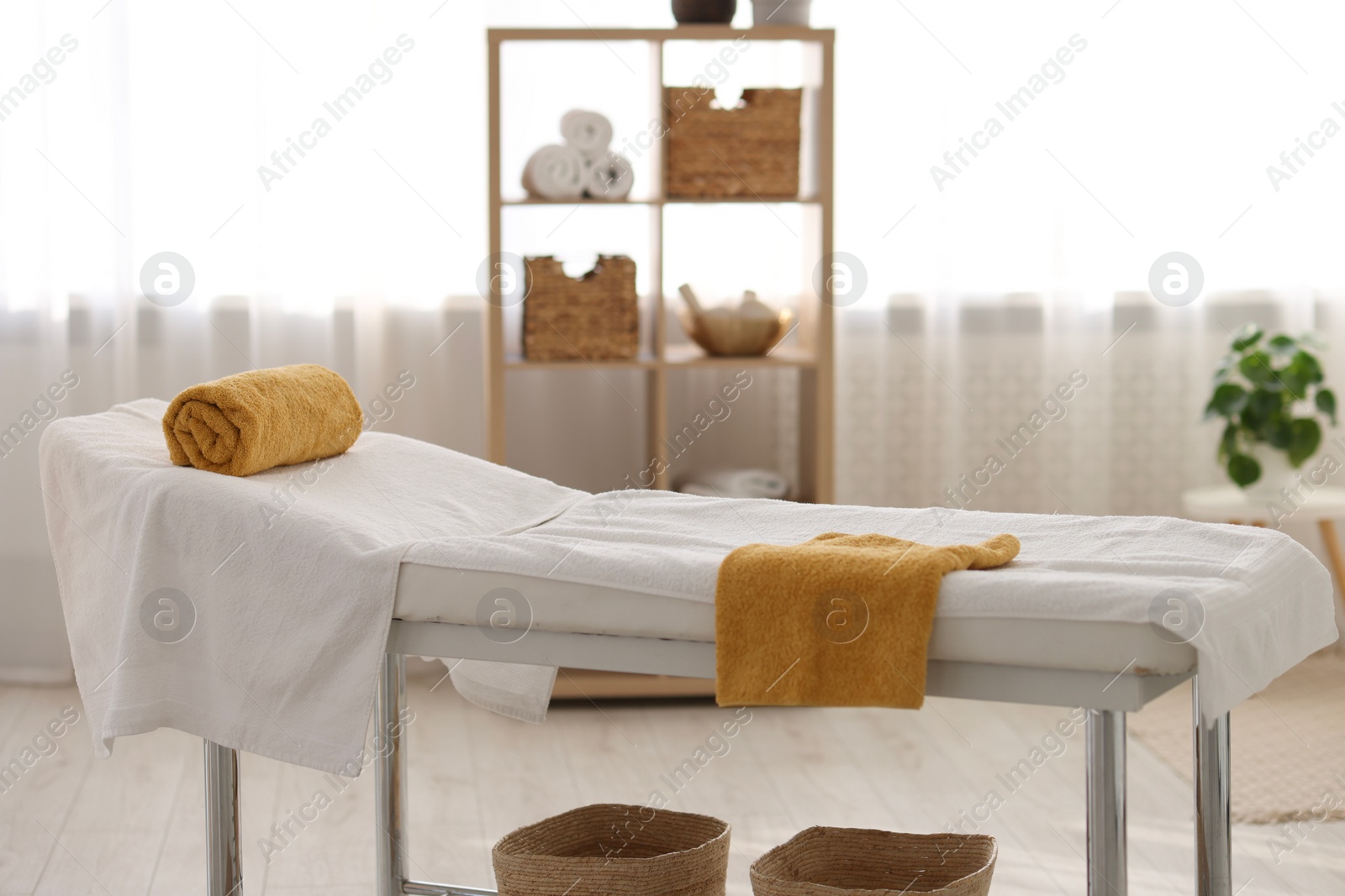 Photo of Comfortable massage table with clean towels in spa center