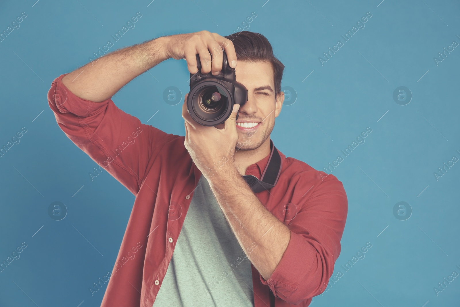 Image of Professional photographer with camera on blue background