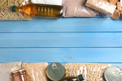 Photo of Different products on turquoise wooden table, flat lay. Food donation