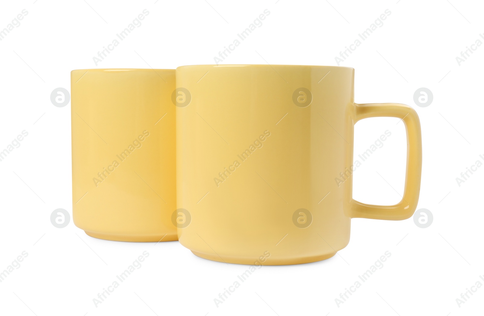 Photo of Two yellow ceramic mugs isolated on white