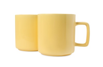 Two yellow ceramic mugs isolated on white