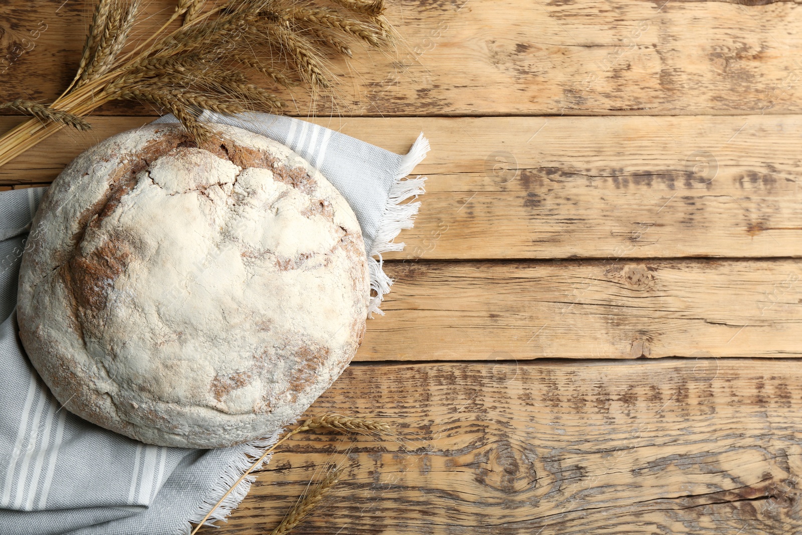 Photo of Tasty freshly baked bread on wooden table, flat lay. Space for text