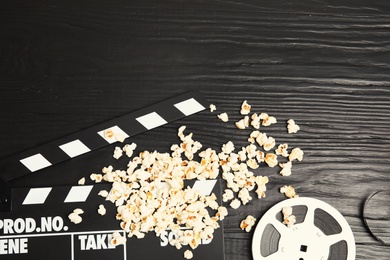 Photo of Flat lay composition with tasty popcorn and space for text on wooden background. Cinema snack