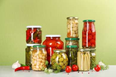 Jars of pickled vegetables and ingredients on light table