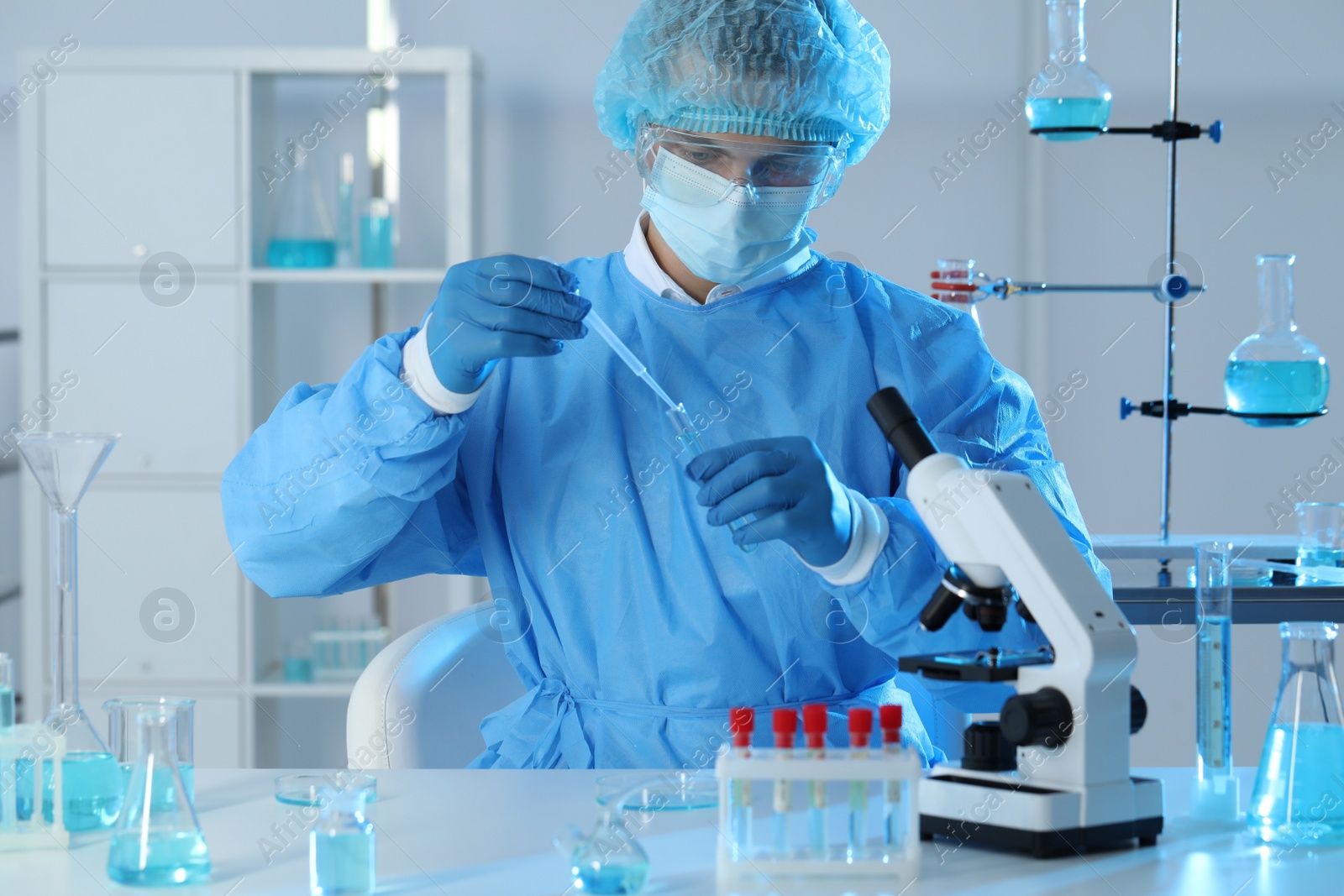 Photo of Scientist dripping sample into test tube in laboratory. Medical research