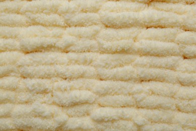 Soft beige knitted fabric as background, top view