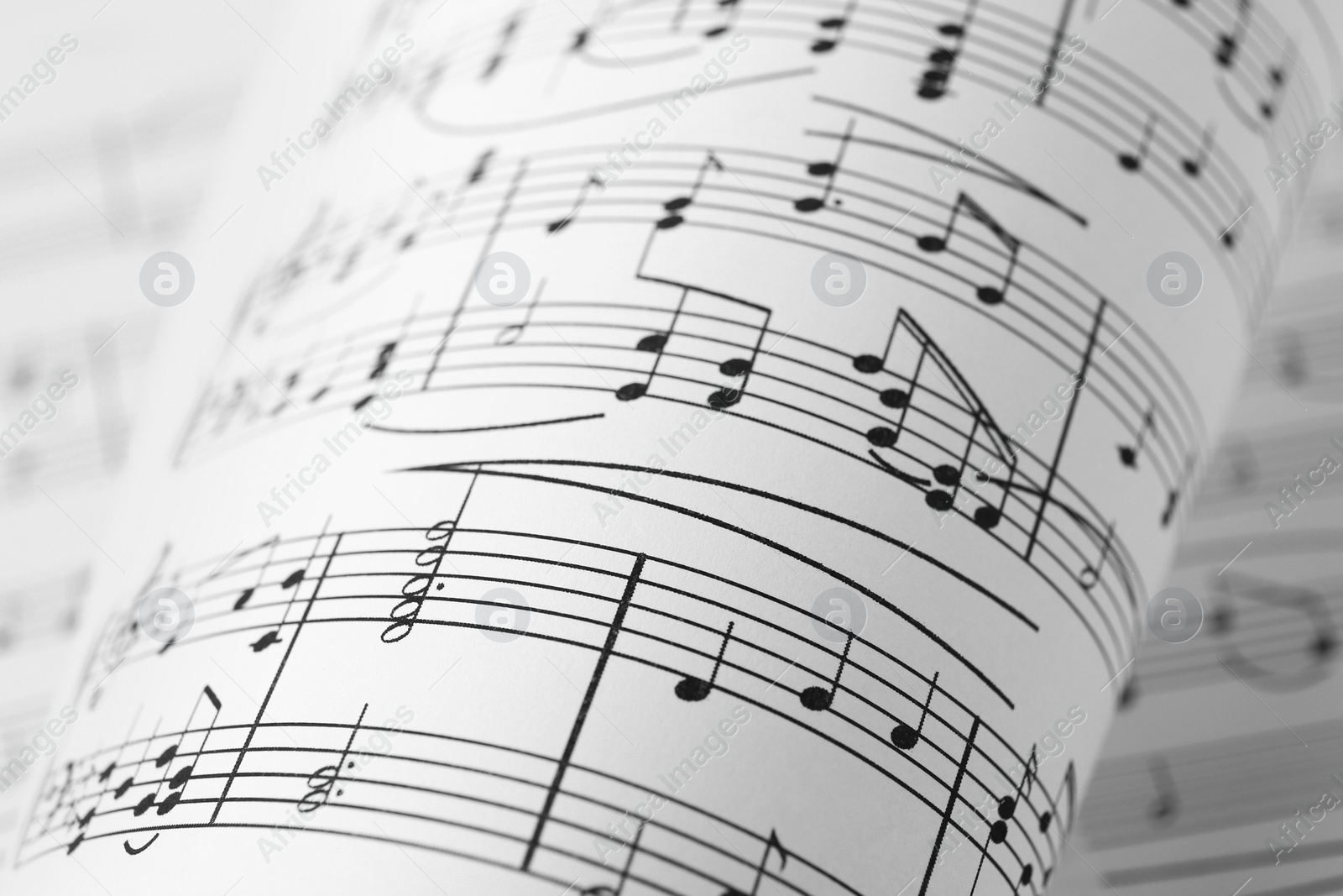 Photo of Sheets of paper with music notes as background, closeup view