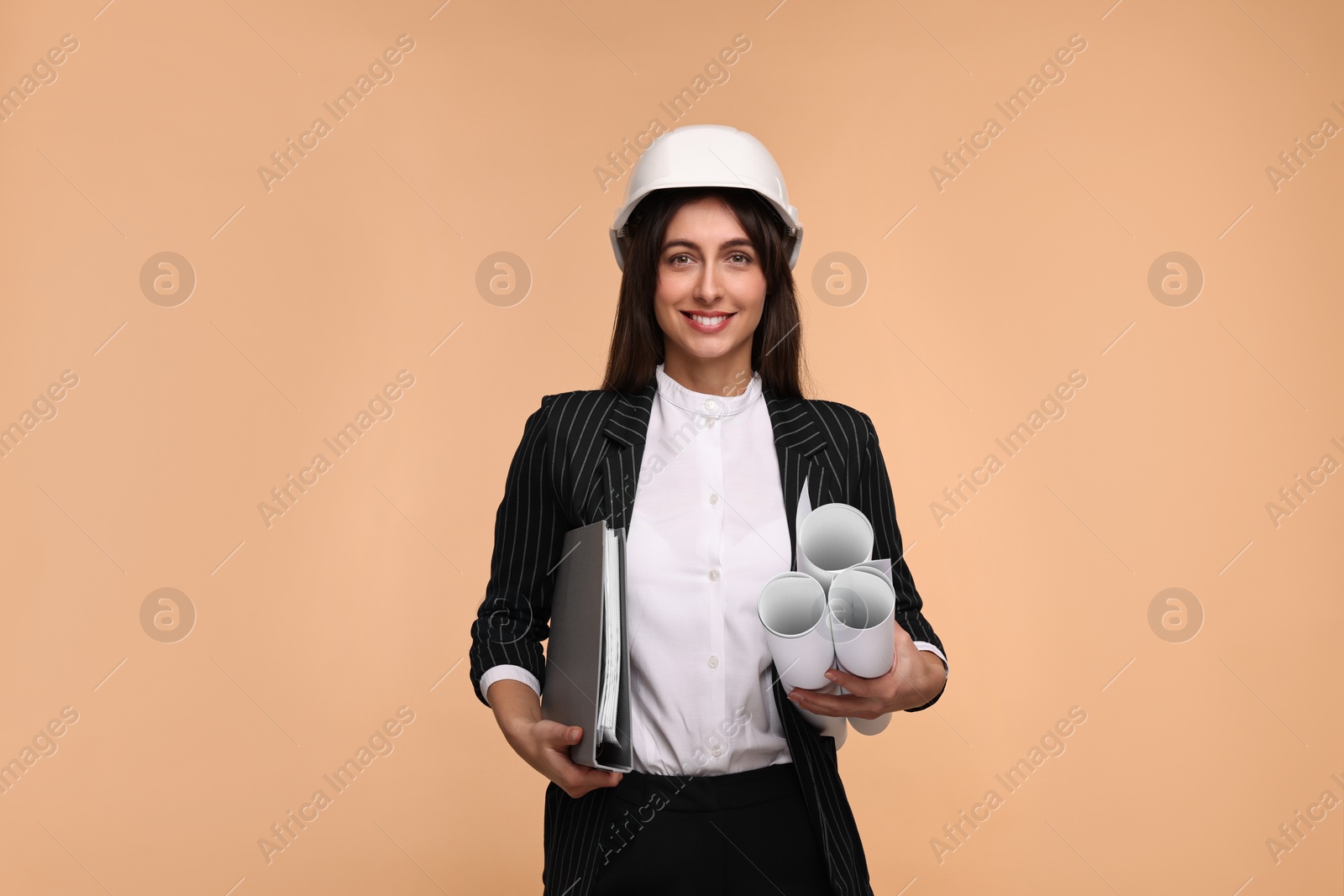 Photo of Architect in hard hat with drafts and folder on beige background