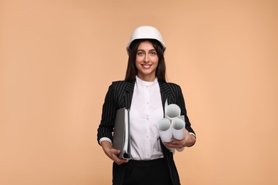 Architect in hard hat with drafts and folder on beige background