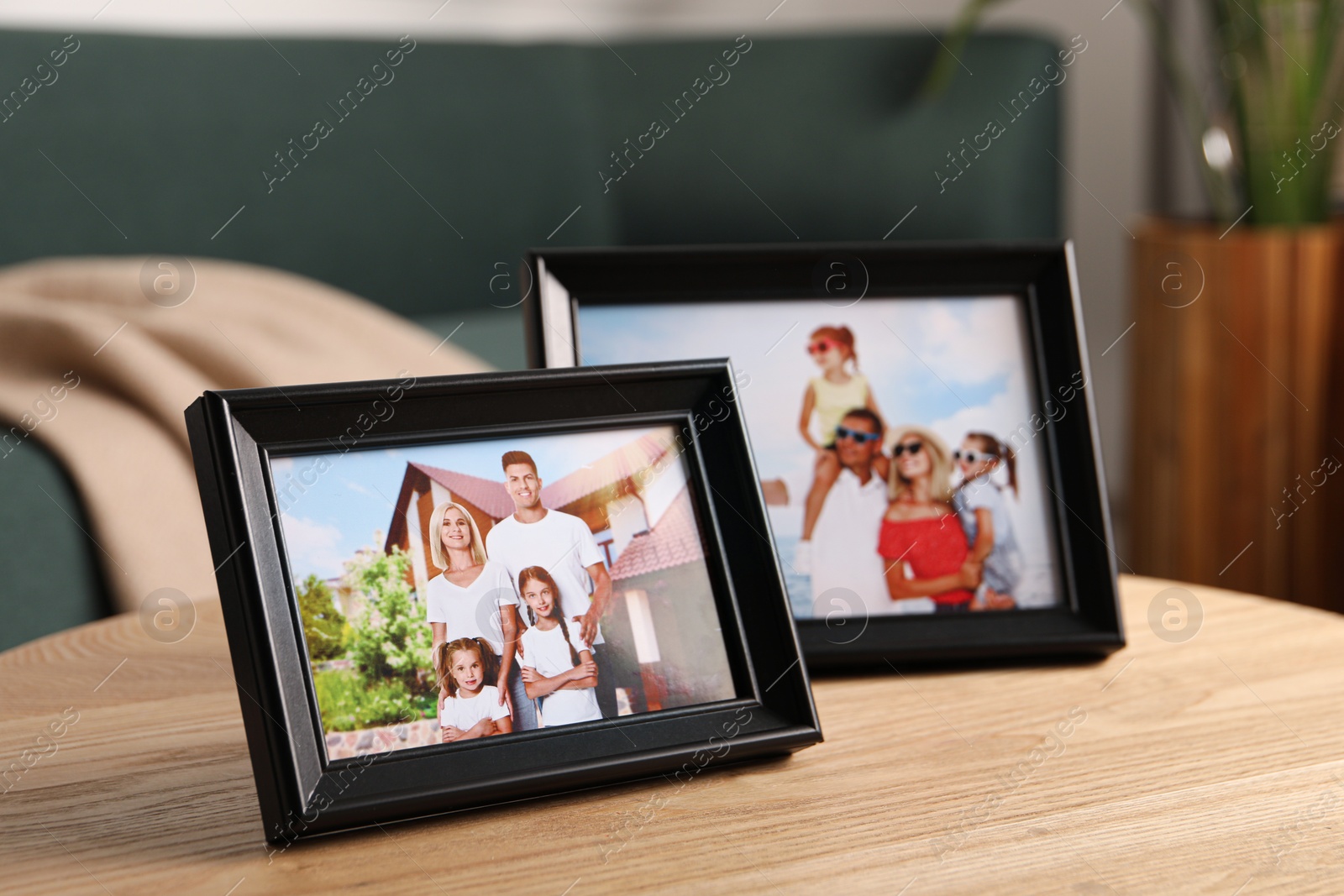 Photo of Frames with family photos on wooden table indoors