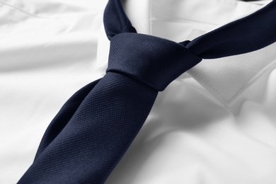 Photo of Black male necktie on white shirt, closeup